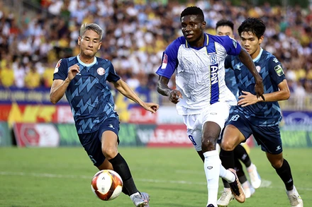 Pha tranh bóng trong trận đấu giữa đội Sông Lam Nghệ An (áo trắng) thắng đội Thành phố Hồ Chí Minh với tỷ số 2-1. (Ảnh TTXVN) 