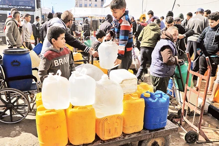 Người dân chờ lấy nước sạch ở phía nam Dải Gaza. 