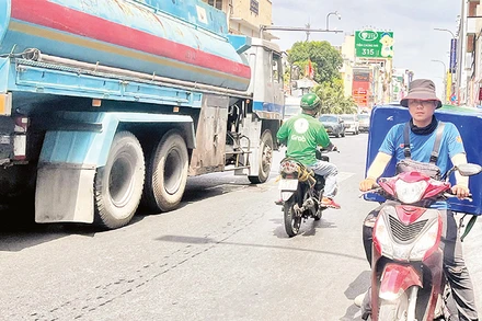 Một người chở hàng hóa đi ngược chiều trên đường Hai Bà Trưng, Quận 1. 