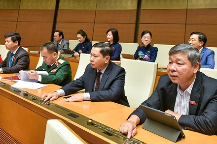 Các đại biểu Quốc hội biểu quyết thông qua Luật Ðất đai (sửa đổi). (Ảnh ÐĂNG ANH) 