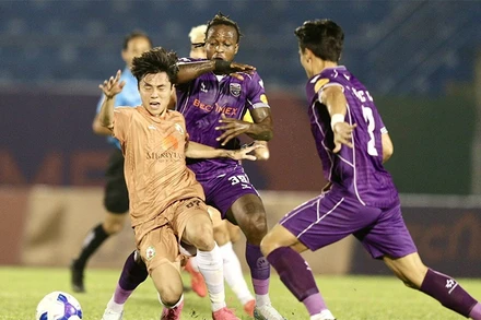 Pha tranh bóng giữa các cầu thủ đội Becamex Bình Dương và đội Quy Nhơn Bình Ðịnh. 
