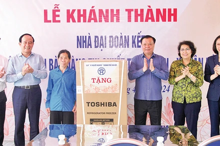 Bí thư Thành ủy Ðinh Tiến Dũng cùng các đồng chí lãnh đạo trao quà mừng nhà mới tặng gia đình bà Hoàng Thị Quyết. (Ảnh Thành Nguyễn) 