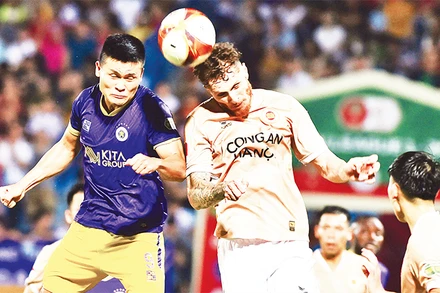 Pha tranh bóng giữa cầu thủ đội Công an Hà Nội (bên phải) với cầu thủ đội Hà Nội FC. (Ảnh TRẦN HẢI) 