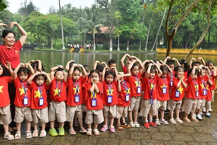 Cô và trò chụp ảnh kỷ niệm bên ao cá Bác Hồ trong Khu Di tích Chủ tịch Hồ Chí Minh tại Phủ Chủ tịch. (Ảnh ÐĂNG KHOA) 