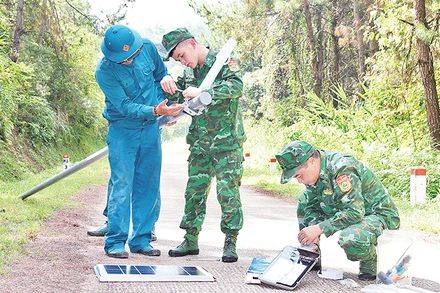 Cán bộ, chiến sĩ Ðồn Biên phòng Chi Lăng lắp đặt đèn năng lượng mặt trời trên đường tuần tra biên giới. 