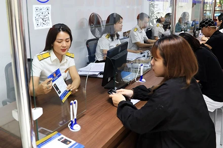 Người dân giao dịch tại Chi cục Thuế quận Tây Hồ, Hà Nội. (Ảnh NGUYỄN QUANG) 