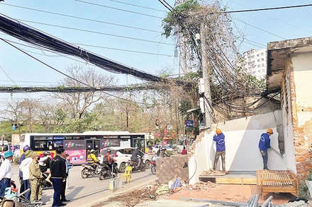 Lực lượng chức năng phường Mai Ðộng tháo dỡ các công trình để bàn giao mặt bằng cho dự án mở rộng đường Tam Trinh. 