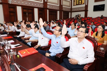 Các đại biểu Hội đồng nhân dân tỉnh biểu quyết thông qua nghị quyết tại kỳ họp. (Ảnh: ĐỨC LAM) 