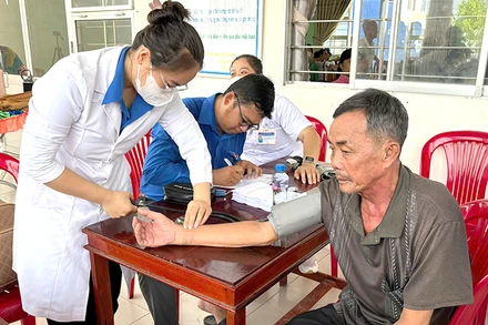 Các y, bác sĩ tình nguyện khám bệnh miễn phí cho người dân xã Phú Điền, huyện Tháp Mười.