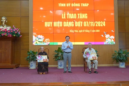 Phó Bí thư Thường trực Tỉnh ủy Đồng Tháp Phan Văn Thắng trao Huy hiệu 65 năm tuổi Đảng. (Ảnh: HỮU NGHĨA)