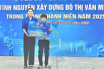 Em Lâm Nguyễn Việt Uyên trao bảng tượng trưng cho em Lý Thiện Đức. (Ảnh: TRUNG THÀNH)