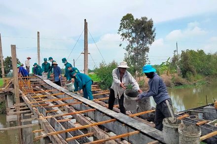 Quân và dân xã Đốc Binh Kiều chung tay xây dựng cầu nông thôn. (Ảnh: HOÀNG KHA)