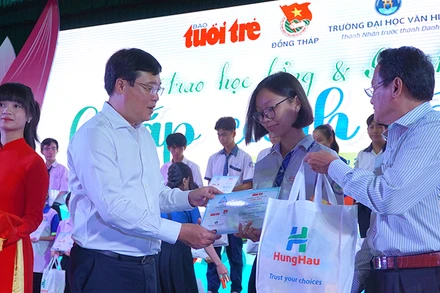 Bí thư Tỉnh ủy Đồng Tháp Lê Quốc Phong và Phó Tổng Biên tập Báo Tuổi Trẻ Nguyễn Hoàng Nguyên trao học bổng, quà cho học sinh. (Ảnh: HỮU NGHĨA)