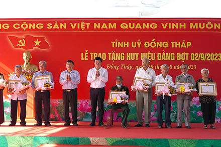 Bí thư Tỉnh ủy Đồng Tháp Lê Quốc Phong trao Huy hiệu Đảng cho các đảng viên. (Ảnh: HỮU NGHĨA)