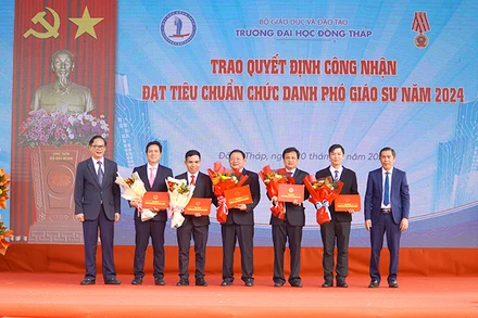 Phó Giáo sư, Tiến sĩ Nguyễn Văn Đệ, Chủ tịch Hội đồng Khoa học và Đào tạo, Phó Chủ tịch Hội đồng chức danh giáo sư cơ sở Trường đại học Đồng Tháp thừa ủy quyền của Chủ tịch Hội đồng giáo sư nhà nước trao Quyết định công nhận đạt tiêu chuẩn chức danh phó giáo sư năm 2024 cho 5 nhà giáo. (Ảnh: HỮU NGHĨA)