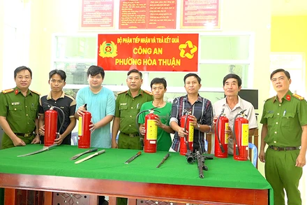 Người dân giao nộp vũ khí tại Công an phường Hòa Thuận và nhận bình chữa cháy. (Ảnh: Công an cung cấp)