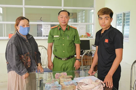 Anh Nguyễn Thanh Duy nhận lại số tiền để quên. (Ảnh: Công an Đồng Tháp)