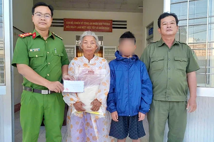 Công an xã An Bình hỗ trợ cháu bé đi lạc. (Ảnh: Công an cung cấp)