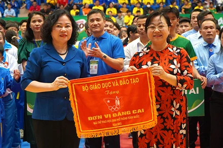 Thứ trưởng Giáo dục và Đào tạo Ngô Thị Minh trao cờ lưu niệm cho Giám đốc Sở Giáo dục và Đào tạo Nguyễn Thúy Hà, đại diện địa phương đăng cai