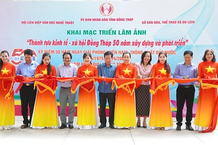 Nghi thức cắt băng khai mạc triển lãm ảnh. (Ảnh: NHƯ ANH)