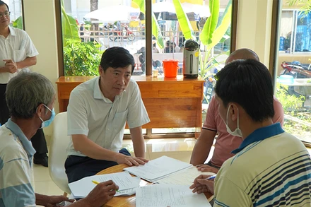 Chủ tịch Ủy ban nhân dân tỉnh Đồng Tháp Phạm Thiện Nghĩa trao đổi với người dân làm thủ tục cấp giấy chứng nhận cơ sở đủ điều kiện an toàn thực phẩm.