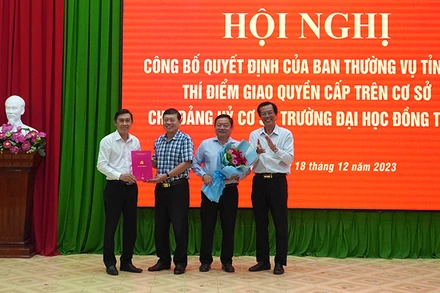 Bí thư Đảng ủy Trường đại học Đồng Tháp Trương Tấn Đạt và Hiệu trưởng Trường đại học Đồng Tháp Hồ Văn Thống nhận Quyết định, hoa của Ban Thường vụ Tỉnh ủy Đồng Tháp. (Ảnh: HỮU NGHĨA)