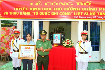 Đại tá Nguyễn Văn Hiểu, Giám đốc Công an tỉnh Đồng Tháp trao Bằng “Tổ quốc ghi công” cho vợ Liệt sĩ Hồ Tấn Dương.