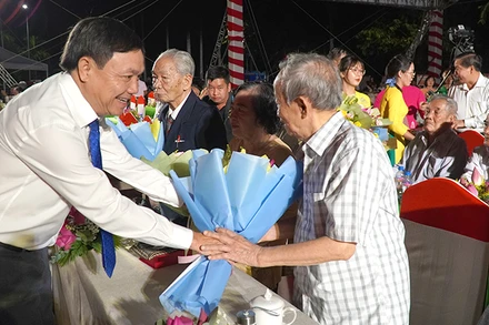 Phó Bí thư Thường trực Tỉnh ủy Đồng Tháp Phan Văn Thắng tặng hoa nhân chứng lịch sử. (Ảnh: HỮU NGHĨA)