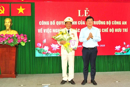 Ủy viên Trung ương Đảng, Bí thư Tỉnh ủy Đồng Tháp Lê Quốc Phong trao Huy hiệu 40 năm tuổi Đảng và tặng hoa chúc mừng Đại tá Nguyễn Văn Hiểu. (Ảnh: Công an cung cấp)