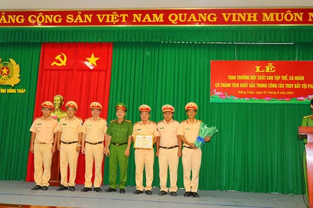 Lãnh đạo Công an huyện Cái Bè, tỉnh Tiền Giang và lãnh đạo Phòng Cảnh sát giao thông, Công an tỉnh Đồng Tháp trao giấy khen cho tập thể có thành tích trong bắt các đối tượng cướp và cố ý gây thương tích. (Ảnh: PHƯỚC THANH)