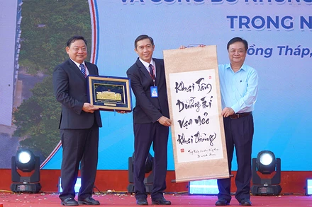 Đồng chí Lê Minh Hoan, Phó Chủ tịch Quốc hội tặng quà lưu niệm cho Trường đại học Đồng Tháp. (Ảnh: HỮU NGHĨA)