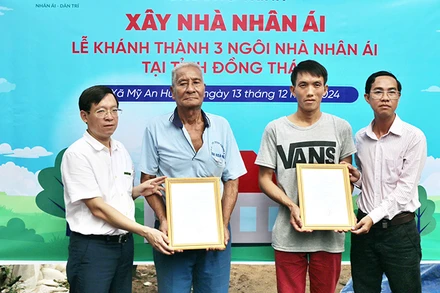  Nhà báo Nguyễn Xuân Toàn, Phó Tổng Biên tập báo Dân trí (bìa trái) và ông Trương Minh Quí, Phó Chủ tịch Ủy ban nhân dân xã Mỹ An Hưng B trao quyết định bàn giao nhà Nhân ái tới 2 hộ dân ở xã Mỹ An Hưng B.