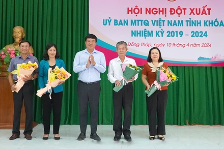 Đồng chí Đinh Văn Dũng (thứ 2 từ phải qua) nhận hoa chúc mừng của Bí thư Tỉnh ủy Đồng Tháp Lê Quốc Phong. (Ảnh: HỮU NGHĨA)