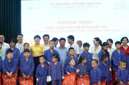 Các đại biểu và nhà hảo tâm tặng quà cho trẻ em khuyết tật được chỉ định phẫu thuật.