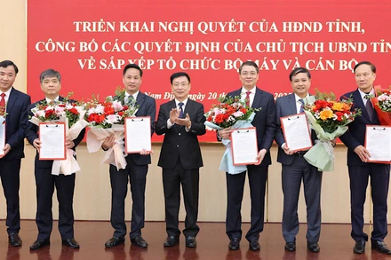 Đồng chí Phạm Đình Nghị, Chủ tịch Ủy ban nhân dân tỉnh Nam Định trao Quyết định và tặng hoa chúc mừng tập thể lãnh đạo Sở Nội vụ. (Ảnh: XUÂN TRƯỜNG)