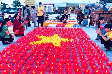 Người dân thắp nến tạo hình lá cờ Tổ quốc tại Chương trình. (Ảnh: XUÂN TRƯỜNG)