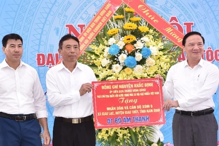 Phó Chủ tịch Quốc hội Nguyễn Khắc Định tặng hoa và quà chúc mừng cán bộ, nhân dân xóm 6, xã Giao Lạc, huyện Giao Thủy, Nam Định. (Ảnh: XUÂN TRƯỜNG).