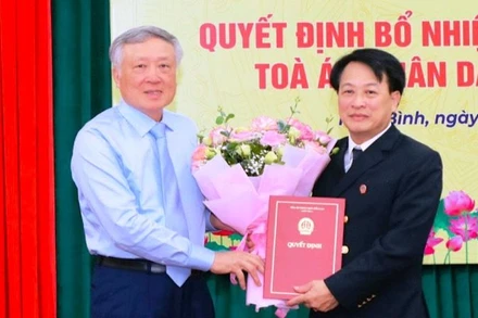 Đồng chí Nguyễn Hòa Bình, Chánh án Tòa án nhân dân tối cao trao Quyết định bổ nhiệm chức vụ Chánh án Tòa án nhân dân tỉnh Ninh Bình cho đồng chí Nguyễn Xuân Sơn. (Ảnh: ĐỨC LAM)