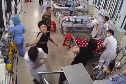 Thanh niên áo đen dùng tay đánh điều dưỡng viên Nguyễn Văn H. (Ảnh cắt từ video clip)