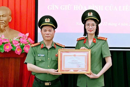 Đại tá Nguyễn Hữu Mạnh, Giám đốc Công an tỉnh Nam Định trao Giấy khen cho Đại úy Trần Mỹ Linh. (Ảnh: BÍCH MẬN)