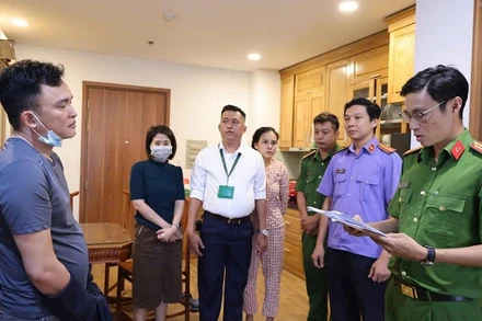 Lực lượng chức năng đọc lệnh khám xét và bắt tạm giam bị can.