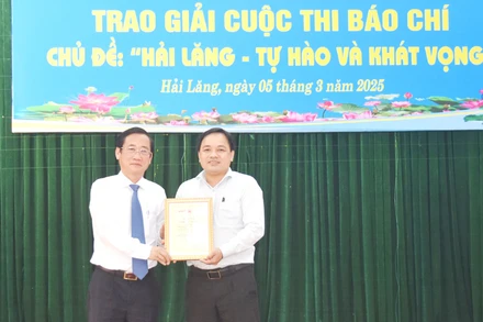 Trưởng Ban Tuyên giáo và Dân vận Tỉnh ủy Quảng Trị Hồ Đại Nam (bên trái) trao giải A cho tác giả.