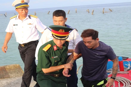 Đưa bệnh nhân Trần Văn Ưu từ tàu cá lên Bệnh xá đảo Song Tử Tây. ( Ảnh: CTV) 
