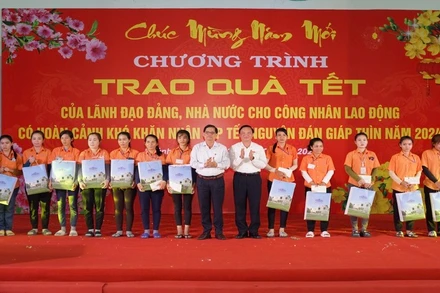 Phó Chủ tịch Quốc hội Nguyễn Khắc Định và Chủ tịch Ủy ban nhân dân tỉnh Khánh Hòa trao quà Tết tặng công nhân có hoàn cảnh khó khăn tại Khu Công nghiệp Suối Dầu. (Ảnh: VÕ TOÀN) 