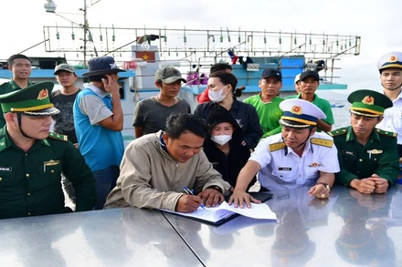 Bàn giao tàu cá BĐ 98833TS cùng 14 ngư dân cho cơ quan chức năng. (Ảnh: NGUYỄN NAM)