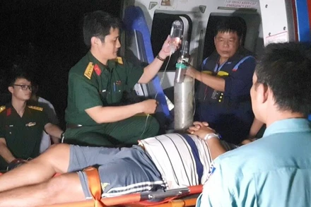 Các lực lượng đưa bệnh nhân lên máy bay vào đất liền tiếp tục điều trị. (Ảnh: NGUYỄN NINH)