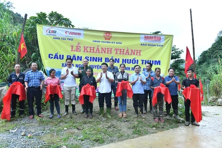 Phó Tổng Biên tập Báo Nhân Dân Quế Đình Nguyên cùng đại diện lãnh đạo chính quyền địa phương, và đơn vị đồng hành cắt băng khánh thành cầu dân sinh bản Huổi Thum, xã Na Ngoi (Kỳ Sơn). (Ảnh Đăng Khoa)