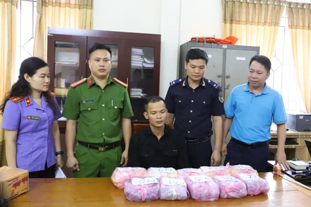 Đối tượng Nguyễn Thành Luân (người ngồi giữa) và tang vật bị thu giữ.