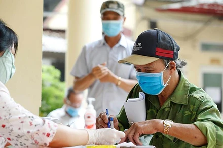 Chi trả tiền hỗ trợ dịch Covid-19 cho các đối tượng người có công và bảo trợ xã hội ở quận Đống Đa, Hà Nội vào tháng 5/2020. (Ảnh: Duy Linh)