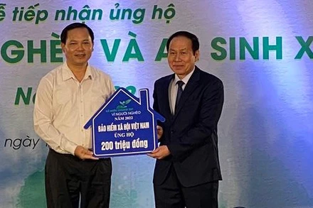 Phó Tổng Giám đốc Bảo hiểm xã hội Việt Nam Chu Mạnh Sinh (trái) trao 200 triệu đồng ủng hộ Quỹ Vì người nghèo năm 2022. (Ảnh: VSS)